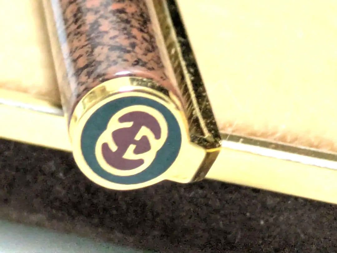 茶色のマーブル模様のボディと金色の金具が特徴的な筆記具