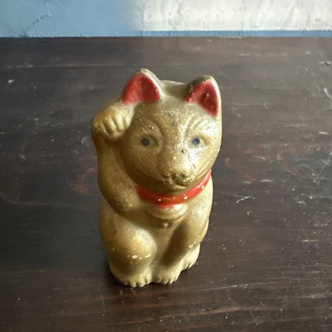 シュールなお顔の陶器製　金色の招き猫貯金箱