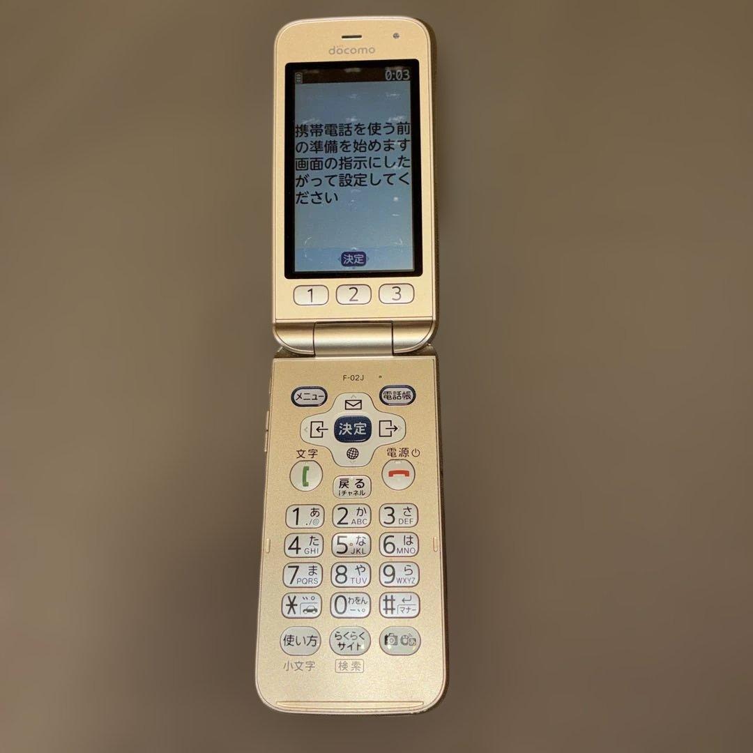 富士通　らくらくホン F-02J ゴールド　卓上フォルダ付き
