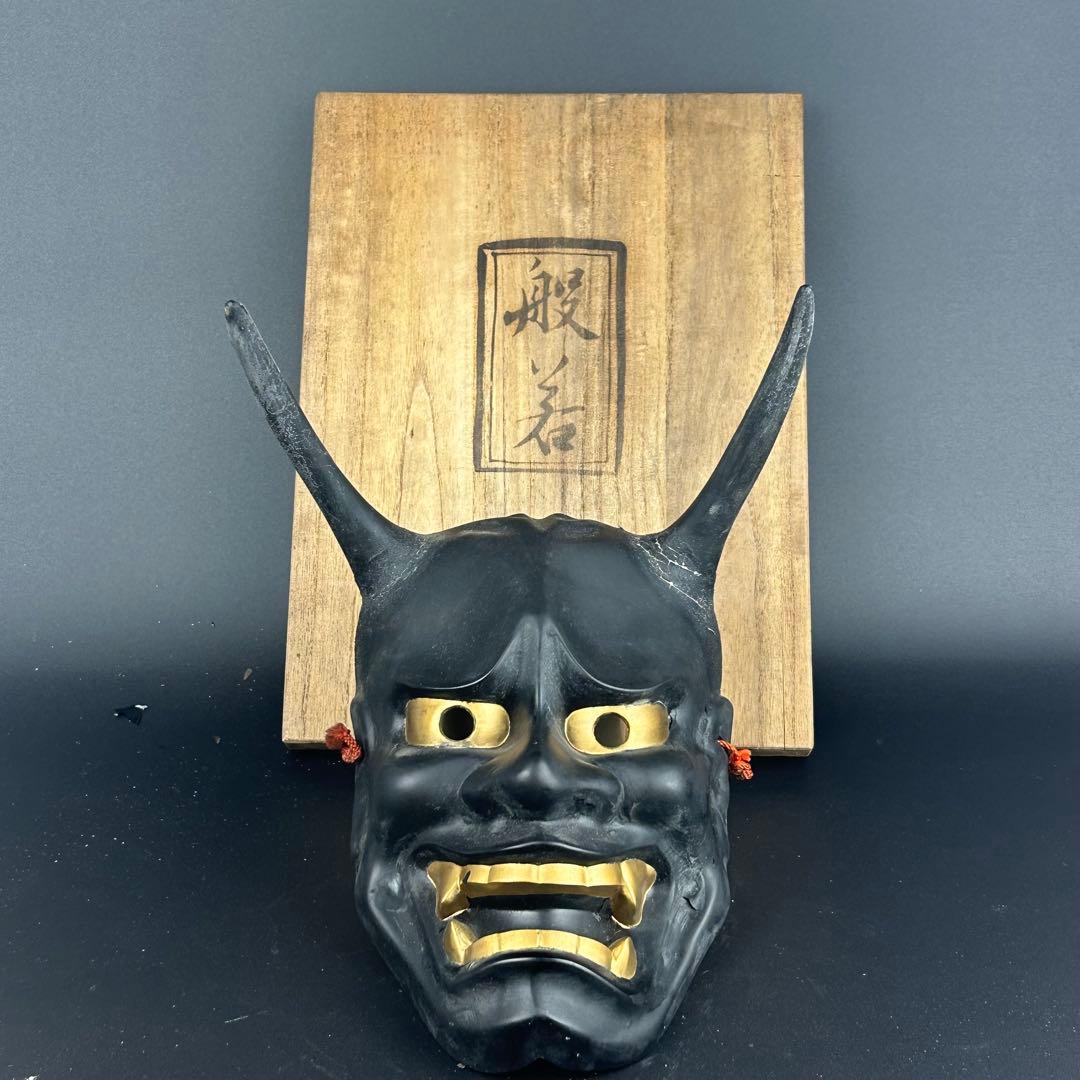 お面　黒と金の角のあるデザイン